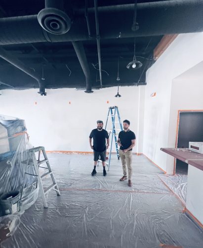 Two men standing in retail space